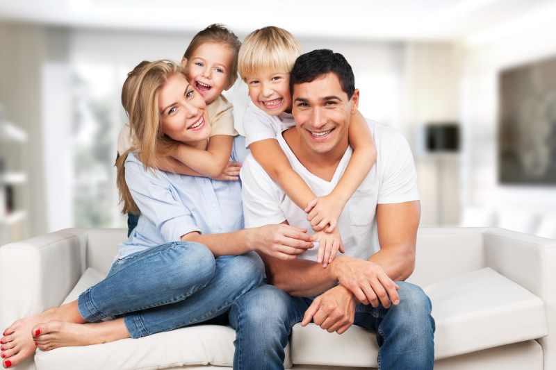 Young family at home smiling at camera